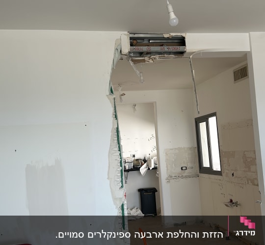 חדר בשיפוץ עם קיר שבור, כלי עבודה על הרצפה